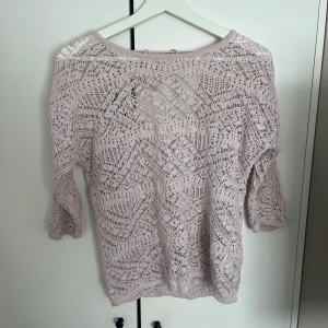 Ljuslila virkad tröja med knytning i ryggen - Söt ljuslila virkad tröja med trekvartsärm . Djup v-ringning i ryggen med knytband för extra detalj😊