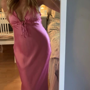 Zara klänning - Säljer en rosa långklänning i satin liknande material ifrån Zara. Den är öppen i ryggen och går ner till fotknölarna på mig som är ca 167. Endast använd en gång,som ny💕