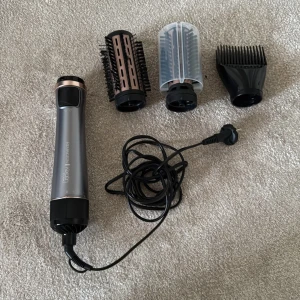 Remington Keratin Protect Rotating Air Styler - Remington Keratin Protect roterande varmluftsborste med flera tillbehör. Inkluderar två borstar, skyddshölje och stylingmunstycke. Produkten ser välvårdad ut med minimalt slitage. Perfekt för att skapa volym och glans i håret.