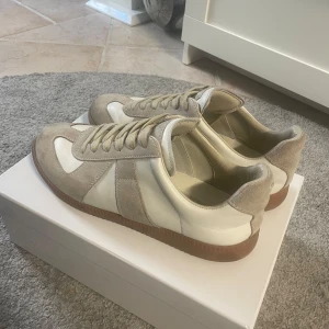 Beige maison margiella skor  - Säljer dessa sjuk snygga skor från maison margiella. Passar till allt och höjer upp outfiten. Inte använda mycket, enbart en liten fläck framme vid tån på vänstern skorn. Pris kan diskuteras vid snabb affär. Inga scam bud! Skriv för minsta lilla fundering 🫡
