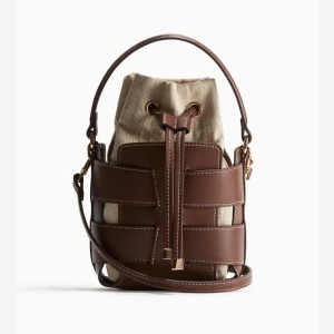Brun och beige bucket bag med snörning - Säljer den populära bruna väska från hm då den inte kommer till användning, använd endast 3-4 gånger!❤️