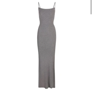 Grå ribbad långklänning från Skims - Säljer min jättefina klänning från Skims då jag aldrig får användning för den. Är använd två gånger och i väldigt fint skick! Är i storlek xxs men den passar en xs/s också.