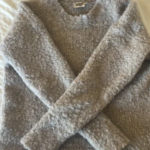 Grå stickad tröja Twist & Tango XS - Supermysig beige stickad tröja från Twist & Tango i storlek XS. Tröjan har en fluffig, grovstickad struktur och rund halsringning. Perfekt för lager på lager under kyliga dagar.