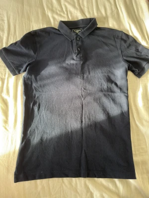 Mörkblå pikétröja  - Snygg mörkblå pikétröja från Dressmann i storlek M. Klassisk krage och tre knappar framtill. Använda fåtal gånger 