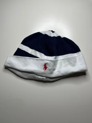 Polo Ralph Lauren mössa mörkblå och vit - Mörkblå och vit Polo Ralph Lauren mössa till barn i mycket bra skick, pm vid intresse.  Storlek: 6M