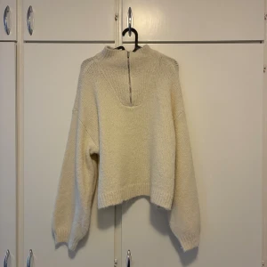 Beige stickad tröja med half zip Vero Moda - Supermysig beige stickad tröja från Vero Moda i storlek S. Tröjan har en cool half zip-detalj vid halsen, ribbade muddar och en lite croppad passform. Perfekt för lager-på-lager och chill dagar. Snyggt och enkelt att matcha med jeans eller kjol.