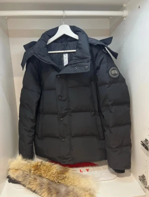 Canada Goose wyndham black logo - Used it last winter myself, but eventually got bored of it and im looking to change to another jacket. (im not open to trades) 🙌🏻  Even though i used it myself for some time, it has 0 flaws with 0 stains. Literally as brand new so the price for it is pretty tight🫡  Bought on Vinted as new with Item verification, and came out as real :)   DIGITAL VINTED RECEIPT AVAILABLE