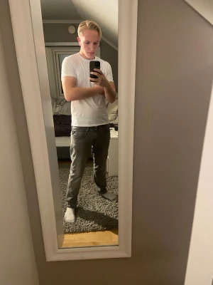 Replay grå jeans straight fit - Säljer ett par grå jeans från Replay med klassisk femficksdesign och raka ben. Jeansen har en mörkgrå ton, snygga detaljer på bakfickorna och Replay-logga vid linningen. Passformen är straight och materialet är mjukt jeans-tyg som sitter skönt hela dagen.