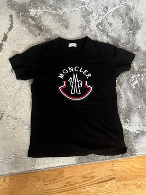 Svart Moncler t-shirt med logga S/M - Svart t-shirt från Moncler , broderad Moncler-logga som passar M/S