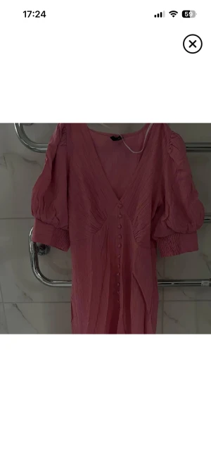 Klänning- Vero Moda - Adoore liknande klänning från Vero Moda i storlek XS. Fluffig vid armen, knappar längs klänningen och slits framtill. För bilder och mer info kom PM 💗