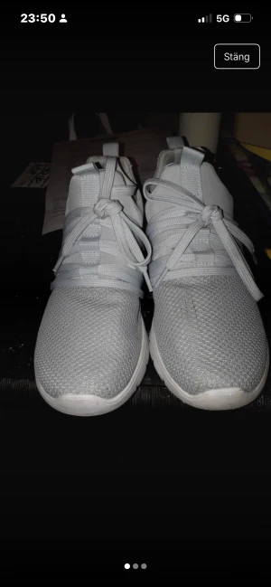 Ljusgrå sneakers med mesh och snörning - Snygga ljusgrå sneakers med ovandel i mesh och detaljer i syntet. Skorna har rund tå, platt sula och bred snörning framtill. Perfekta för dig som gillar en clean och sportig look. Passar till både jeans och träningskläder.