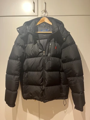 Polo Ralph Lauren Gorham dunjacka - Svart pufferjacka från Polo Ralph Lauren i storlek L. Grym jacka som tyvärr inte kommit till användning lika mycket som jag tänkt, har använts ett par gånger. Givetvis äkta och har kvar taggarna. Kan skicka orderbekräftelse från Boozt ifall det önskas. 