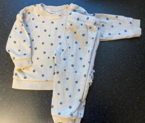 Prickiga mjukisbyxor från BEBE, 80 cl - Säljer ett par mjukisbyxor från BEBE i storlek 80 cl, med ljusbeige bas och blå prickar. Byxorna har resår i midjan och muddar vid bensluten. Mjukt och mysigt material på insidan, perfekt för chill dagar hemma.