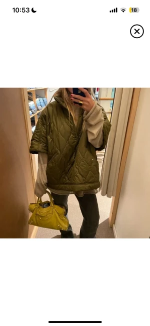 Quiltad grön pufferjacka - Säljer en oversized quiltad pufferjacka i mörkgrön färg med korta ärmar. Jackan har en cool, loose passform och är tillverkad i syntetmaterial. Perfekt för dig som gillar streetstyle och vill sticka ut med en unik look.