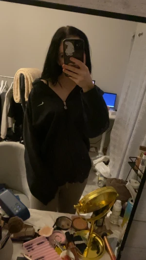 Svart Nike hoodie med dragkedja - Svart hoodie från Nike med vit logga på bröstet och hel dragkedja framtill. Hoodien har en loose passform och långa ärmar, perfekt för chill dagar. har fickor på sidorna. Storleken är xl men passar som en oversized hoodie för mig som är S