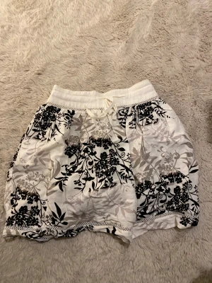 Blommig kjol  - Säljer en fin blommig kjol från XMG i strl 36. Kjolen har dragkedja och fina detaljer längs kanten, även ett luftigt lent material. Knappt använt den och är i bra skick!💞