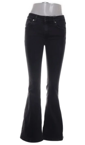 Svarta bootcut jeans - Snygga svarta jeans med bootcut passform och klassisk femficksdesign. Jeansen har en smalare siluett upptill som går ut i bredare ben nedtill. Perfekta för dig som gillar en retro vibe och vill ha ett par jeans som sticker ut.