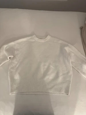 Vit stickad tröja från Bikbok - Mysig vit stickad tröja från Bikbok i storlek M. Tröjan har rund hals, långa armar. Perfekt för att hålla sig varm under kyliga dagar. Enkel och är lätt att matcha. Gillar du oversized , är denna bäst för dig !