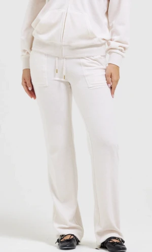 Vita mjukisbyxor med snörning - Säljer ett par vita mjukisbyxor med raka ben och snörning i midjan. Byxorna har fickor fram och bak, samt bred resår i midjan för extra komfort. Perfekta för en chill och avslappnad stil.