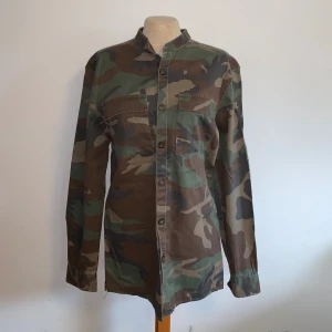 Camouflage overshirt från Pull&Bear - Säljer en snygg camouflagefärgad overshirt från Pull&Bear i storlek S (upplevs som lite större, oversized) Skjortan har knäppning framtill och två bröstfickor. 