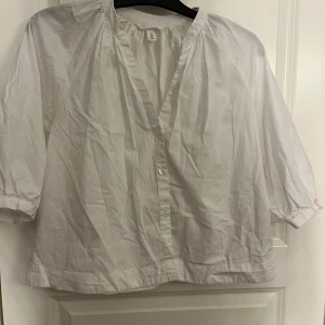 Vit blus med trekvartsärm från H&M - Luftig vit blus från H&M med trekvartsärmar och knappar framtill. 