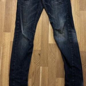 Levis 511 mörkblå jeans herr - Mörkblå Detroit jeans med snyggt slitna detaljer och klassiska kontrastsömmar. Modellen är slim och har en rak passform med normal midja. Jeansen är tillverkade i bomull och har en autentisk tvättad look.det finns ett litet håll som jag knäppt kort på.