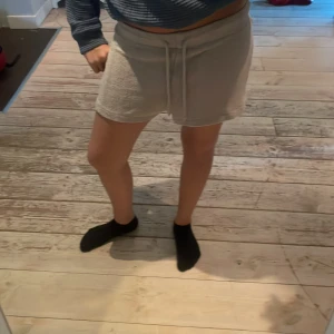 Beige frottéshorts från H&M - Mysiga beige shorts från H&M i frottématerial med snörning i midjan. Modellen är loose fit och har en mjuk, lite fluffig yta som känns chill och skön. Perfekt för lata dagar eller när du vill ha något bekvämt på dig. Midjan är midwaist och de har en enkel, stilren look💗