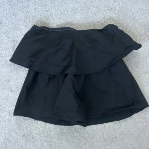 Svart volangtopp - Jättefin topp med volang som endast är använd en gång! Köpt på VeroModa. Materialet är ordentligt och ”prassligt”, med inte så att den låter massor när man rör på sig❣️