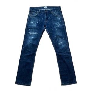 East West slitna blåa jeans - Säljer ett par slitna jeans från East West i storleken 33/32. Dom har en unik design och dom är svåra att få tag på. Skirv för funderingar. 