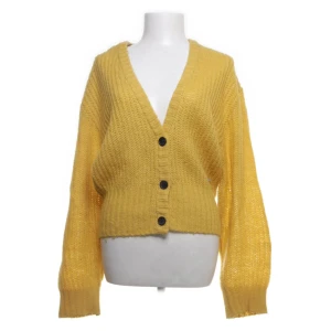 Gul kofta från American Today - Mysig gul kofta från American Today med v-ringning och svarta knappar framtill. Köpt på Sellpy. Pris kan diskuteras!