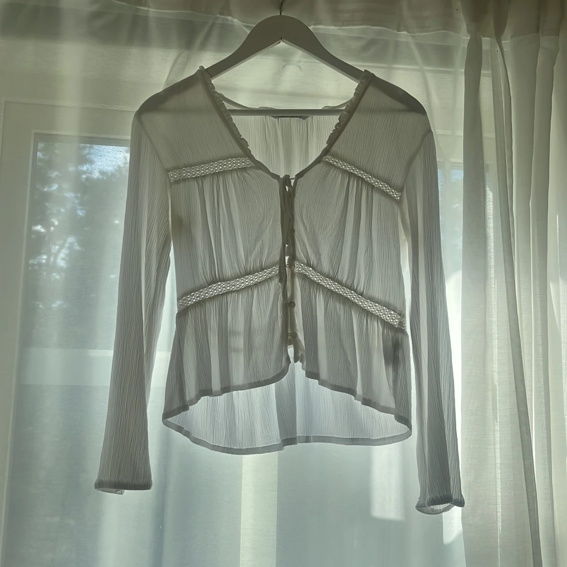 Vit blus med knyt och spetsdetaljer