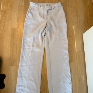 Bik bok beige byxor  - Eleganta ljusbeige byxor från Bik Bok med vida ben. Byxorna har en klassisk design med pressveck och hällor för bälte. Använda fåtal gånger och i fint skick. Storlek 36 