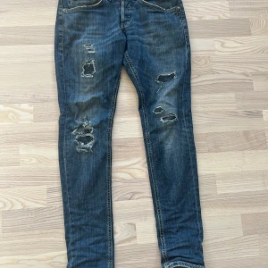 Dondup George jeans - Snygga blå skinny jeans från dondup George med coola slitningar och trasiga detaljer på benen. Hör av dig vid frågor eller funderingar.