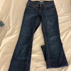 Blå bootcut jeans från Perfect Jeans - Snygga mörkblå bootcut jeans från Perfect Jeans i klassisk denim med kontrastsömmar och fickor med lock och knapp bak. Modellen har normal passform och är perfekta för dig som gillar en tidlös look med lite utsvängda ben.