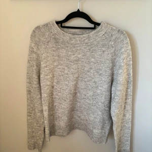 Ljusgrå stickad tröja Vero Moda - Mysig ljusgrå stickad tröja från Vero Moda med rund halsringning. Den är väldigt nopprig och väl använd. Den är i storlek M.💓