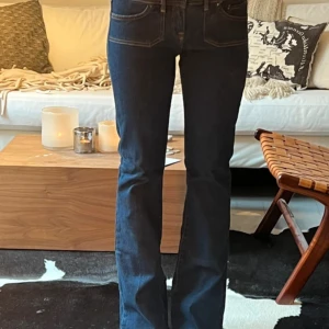 Low waist jeans - Snygga mörkblå jeans från pepe jeans med klassisk bootcut-passform och låg midja. Jeansen har fem fickor, tydliga sömmar och sitter riktigt bra. Perfekta för dig som gillar en tidlös och cool look.