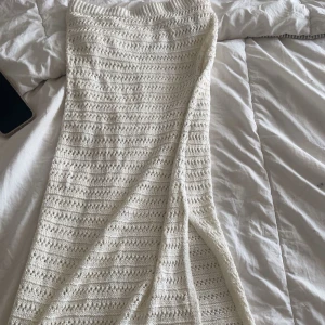 Vit stickad långkjol med slits - Superfin vit stickad långkjol med snygg slits på sidan. Kjolen har ett mönster av virkade ränder och är perfekt för en chill och somrig look.  Köpte för 300 säljer för 150 