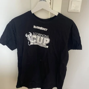 Svart Scorpions Cup t-shirt SOL'S - Svart t-shirt från SOL'S med coolt Scorpions Cup-tryck och innebandytema på bröstet. Klassisk rund hals och korta ärmar. Materialet är mjuk bomull, perfekt för sport eller häng med kompisar. Snygg kontrast med vitt tryck framtill.