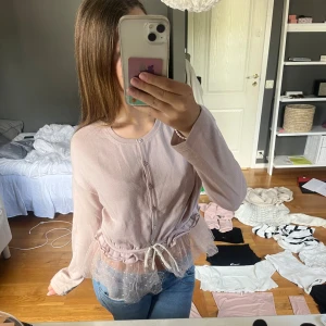 Ljusrosa kofta från RED Valentino - Supersöt ljusrosa kofta från RED Valentino med knappar framtill och volangkant i transparent tyll med små prickar. Koftan har dragsko i midjan och långa ärmar. Perfekt för dig som gillar romantiska detaljer och en feminin look. Jag vet inte om den är äkta köpte den av en vän för 500.