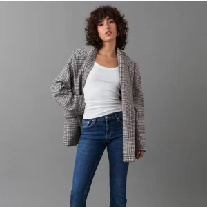 Blå bootcut jeans med låg midja - Snygga blå bootcut jeans med låg midja och utsvängda ben. Jeansen är i stretchig denim med dragkedjegylf, normal benlängd och klassiska fickor både fram och bak. Perfekta för dig som gillar en trendig och avslappnad look.