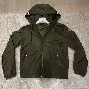 Moncler grön vindjacka med huva - Säljer nu denna supersnygga windbreaker från moncler🤩 Jackan är i jättebra skick och har endast en liten defekt på armen💫