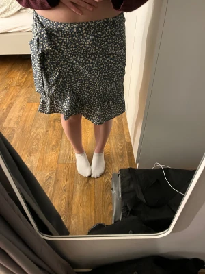 Blommig omlottkjol med volang - Supersöt omlottkjol med blommigt mönster i blått och vitt. Den är i storlek xs från Only 