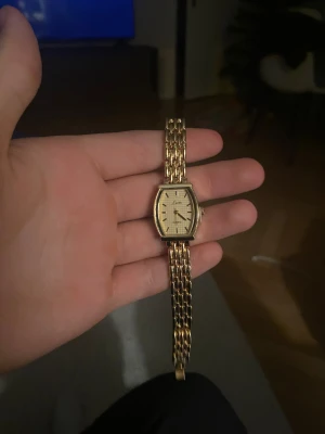 Vintage guldklocka  - Klockan är i ett fint skick utan repor eller andra defekter. Sen snurrar på fint med ett helt nytt batteri installerat.  Klockans längd/storlek går att justera hemma från 8 cm längd till 19 cm längd med hjälp av en nål 📌