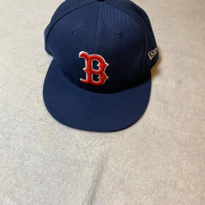 Keps - Snygg mörkblå Boston Red Sox keps från New Era 59FIFTY med röd och vit broderad B-logga framtill och MLB-logga bak. Platt skärm i svart och klassisk passform. Perfekt för dig som gillar sportig streetstyle. Helt ny köpt för 500kr säljer för 200kr