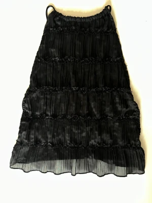Svart topp med öppen rygg - Supersnygg svart volang topp med knytningar i ryggen. (Aldrig använd bara testad)