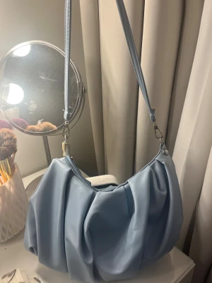 Blå handväska - Säljer min snygga handväska, andvänd fåtal gånger, inga tecken på slitage, förutom lagningen på vänstra sidan handtaget. Men den syns knappt. Köpt på shein för några år sedan. Kom privat för mer info och bilder🥰