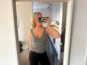 Grå croppad linnetopp med volang - Säljer en grå croppad linnetopp med djup v-ringning och volangdetaljer vid axelbanden. Toppen är ärmlös och har en loose passform som ger en avslappnad vibe. Perfekt för varma dagar och enkel att matcha med jeans eller kjol.