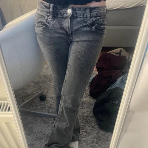 Grå bootcut jeans - Snygga grå jeans från Gina Tricot i low waist bootcut-modell. Säljer då dem ej kommer till användning. Midjemått: 37cm