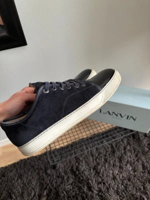 Lanvin sneakers med svart lacktå - Mörkblå lanvin UK 9 motsvarar 44/45. Mycket fint skick och inga defekter, har används men samtidigt väl omhändertagna. Box, skopåse och nya oanvända snören medföljer😁