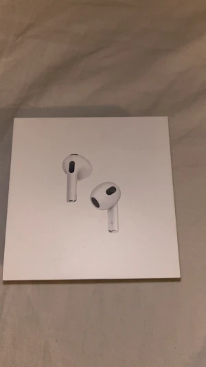 AirPods (3rd generation) - Apple AirPods (3rd generation) med Lightning-laddningsetui. Komplett i originalförpackning med laddkabel och dokumentation. Produkten ser ut att vara i mycket gott skick, utan synliga defekter eller slitage. Perfekt för trådlös musik och samtal med hög ljudkvalitet. Pris kan diskuteras!
